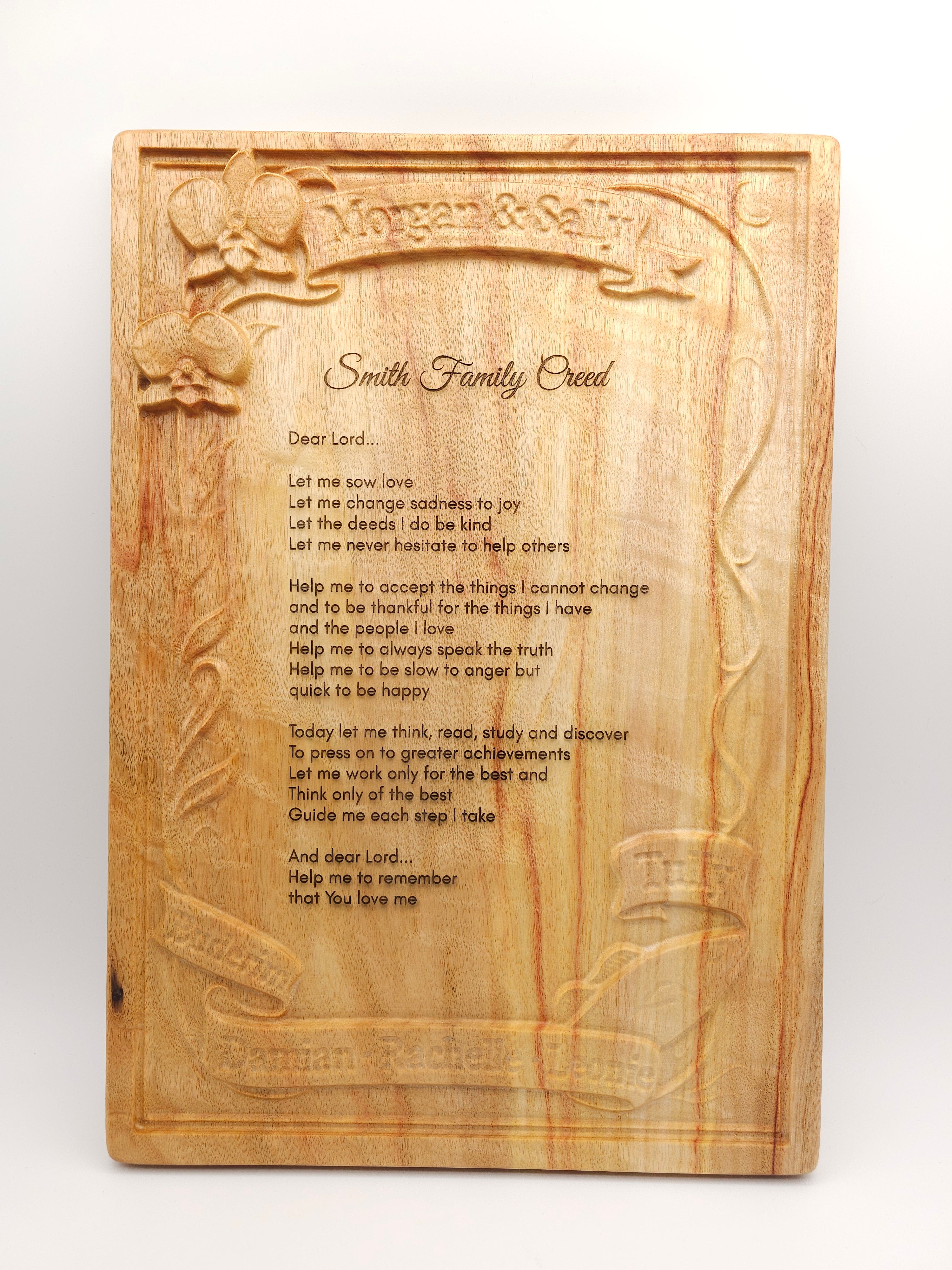 Wooden cutting board with engraved text and designs on a white background