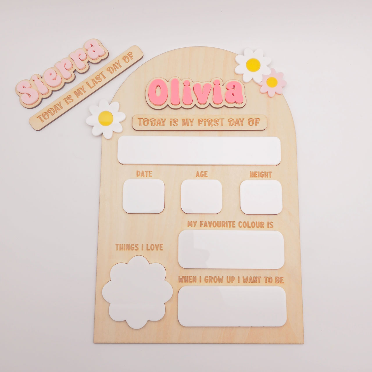 Wooden first day of school sign with name 'Olivia' and decorative elements on a light background