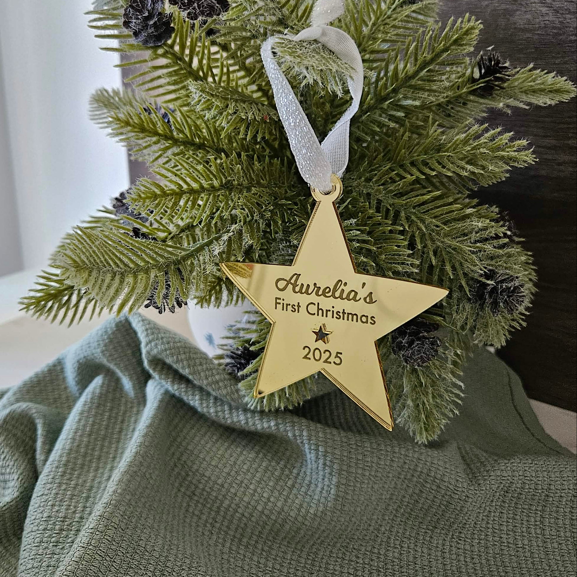 Decorative Christmas ornament with a gold star tag on a green fabric background