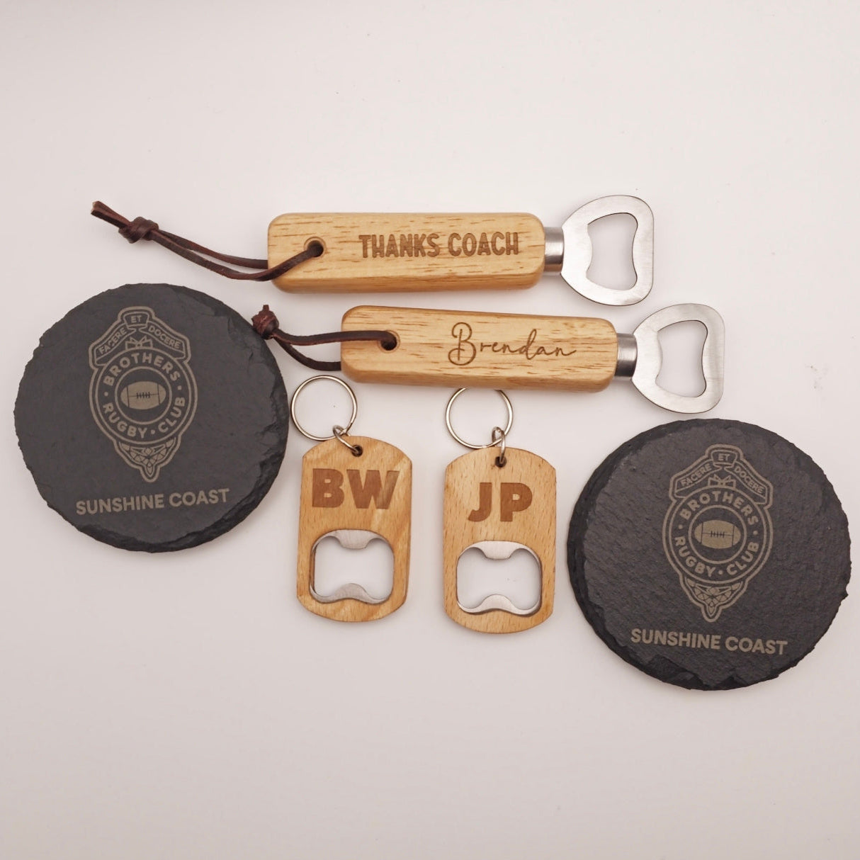 Collection of personalized bottle openers and keychains on a light background