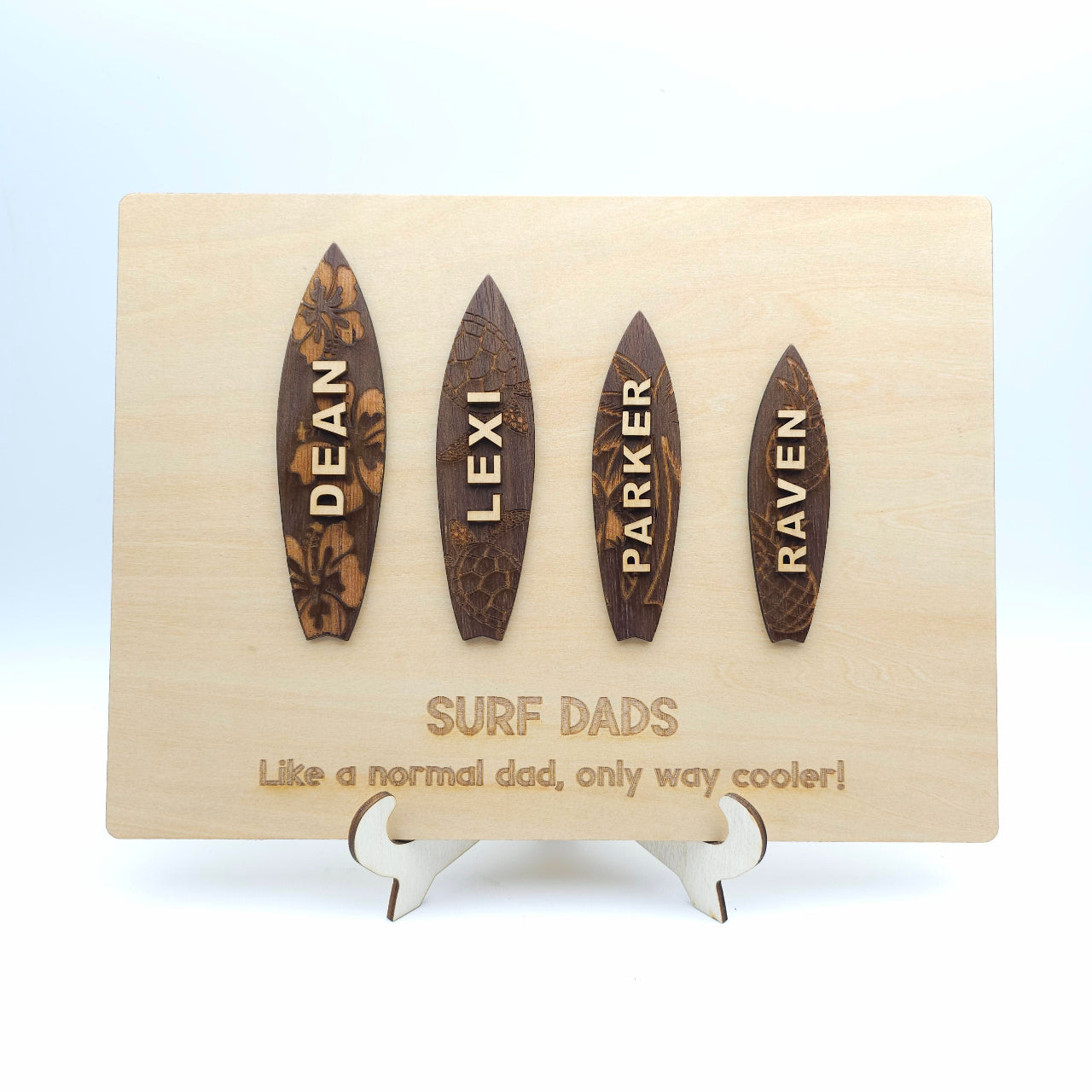 Four wooden surfboard-shaped nameplates with engraved names on a stand with text below.