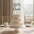 Black acrylic cake topper with 'Mr & Mrs Downies' text on a white background