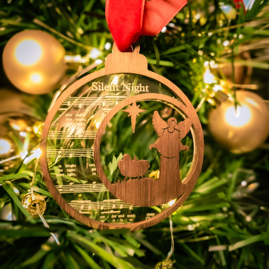 Wooden Christmas ornament with 'Silent Night' lyrics on a decorated tree