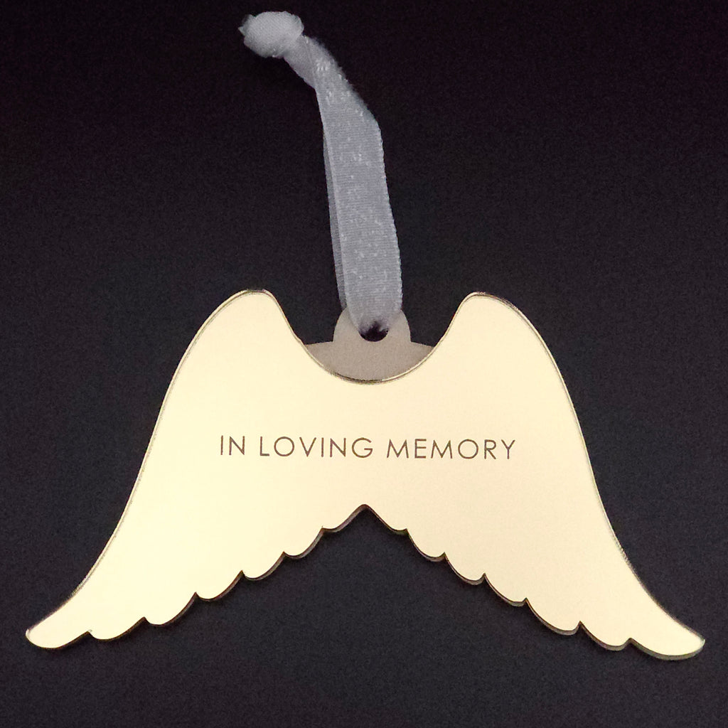 Angel wing-shaped ornament with 'In Loving Memory' text on a black background