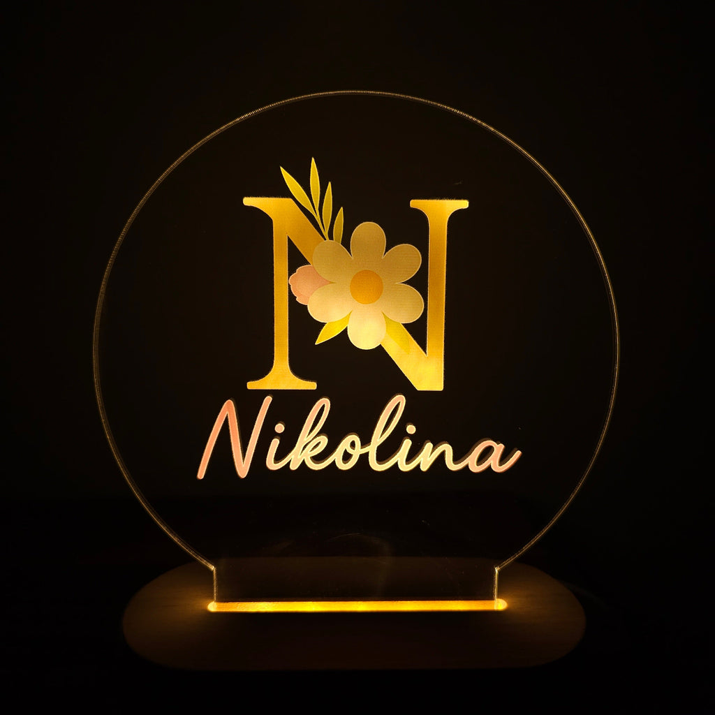 Decorative sign with floral design and 'Nikolina' text on a black background