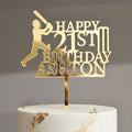 Gold birthday cake topper with 'Happy Birthday Ashton' on a gray background