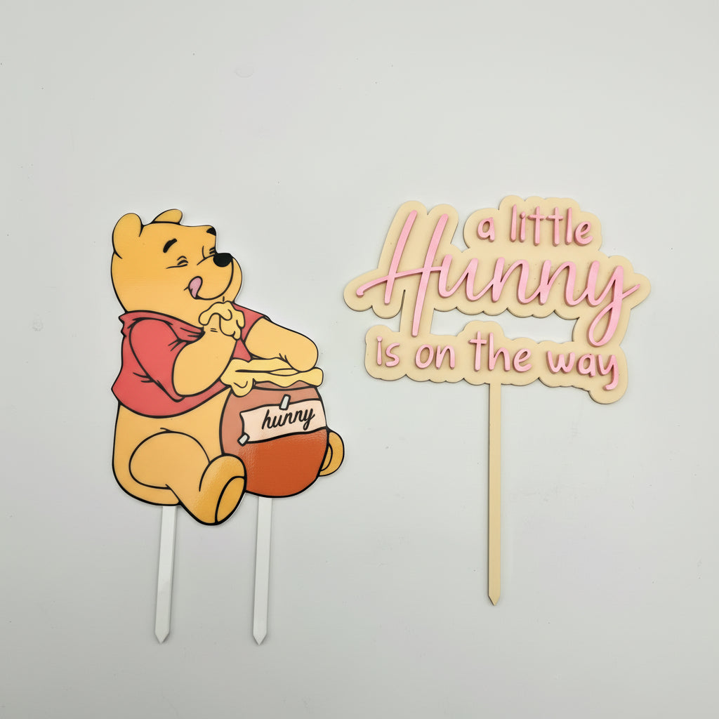 Cartoon bear holding a honey pot with 'a little Hunny is on the way' text on a white background