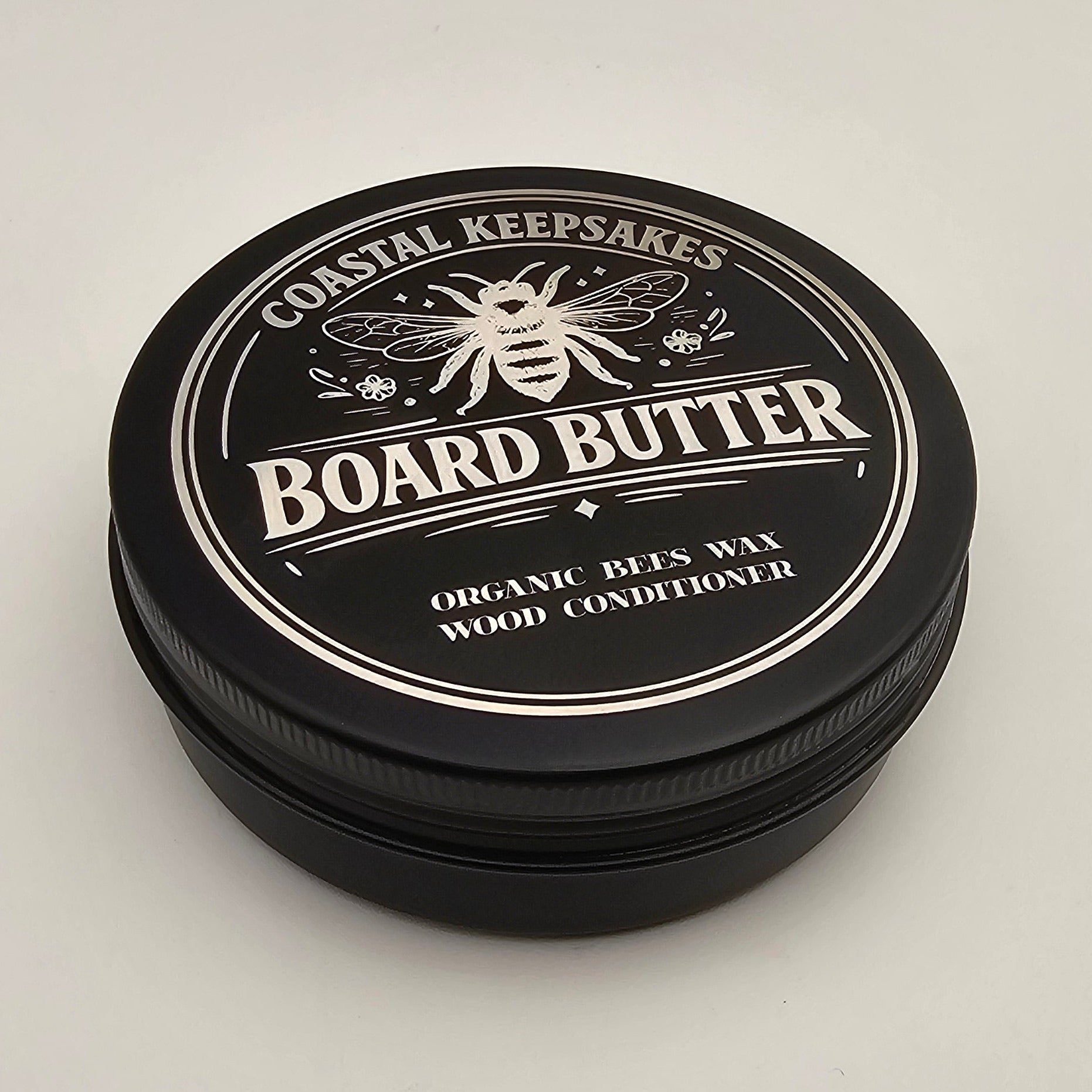 Black container of Board Butter on a light gray background