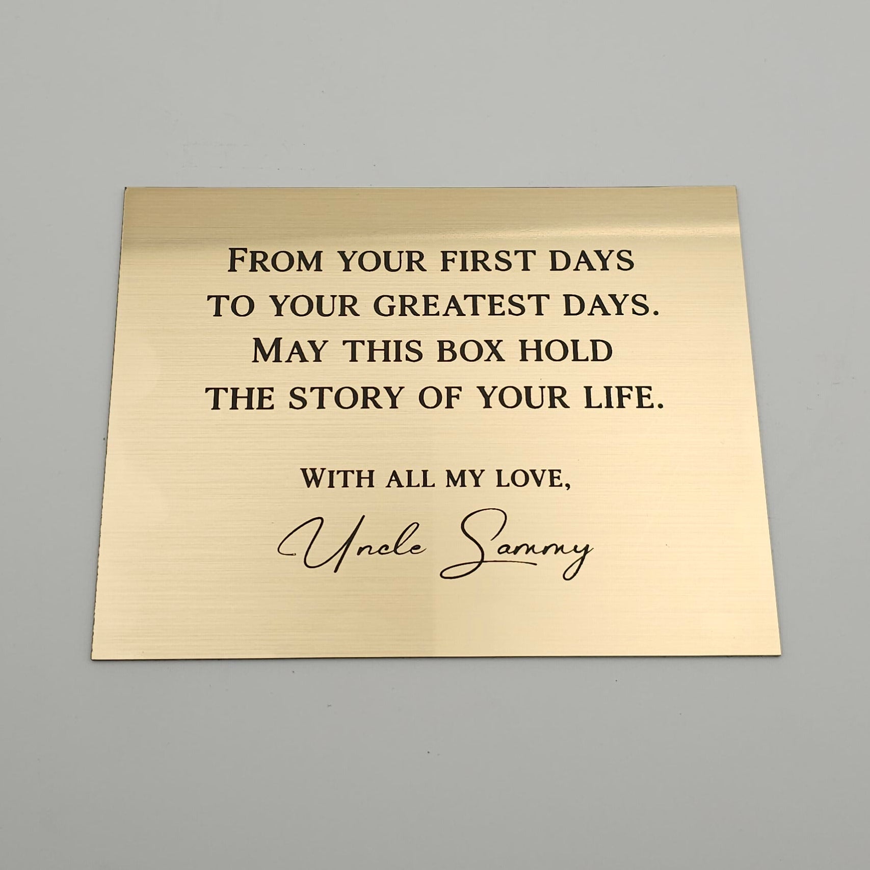 Gold box with engraved text on a gray background