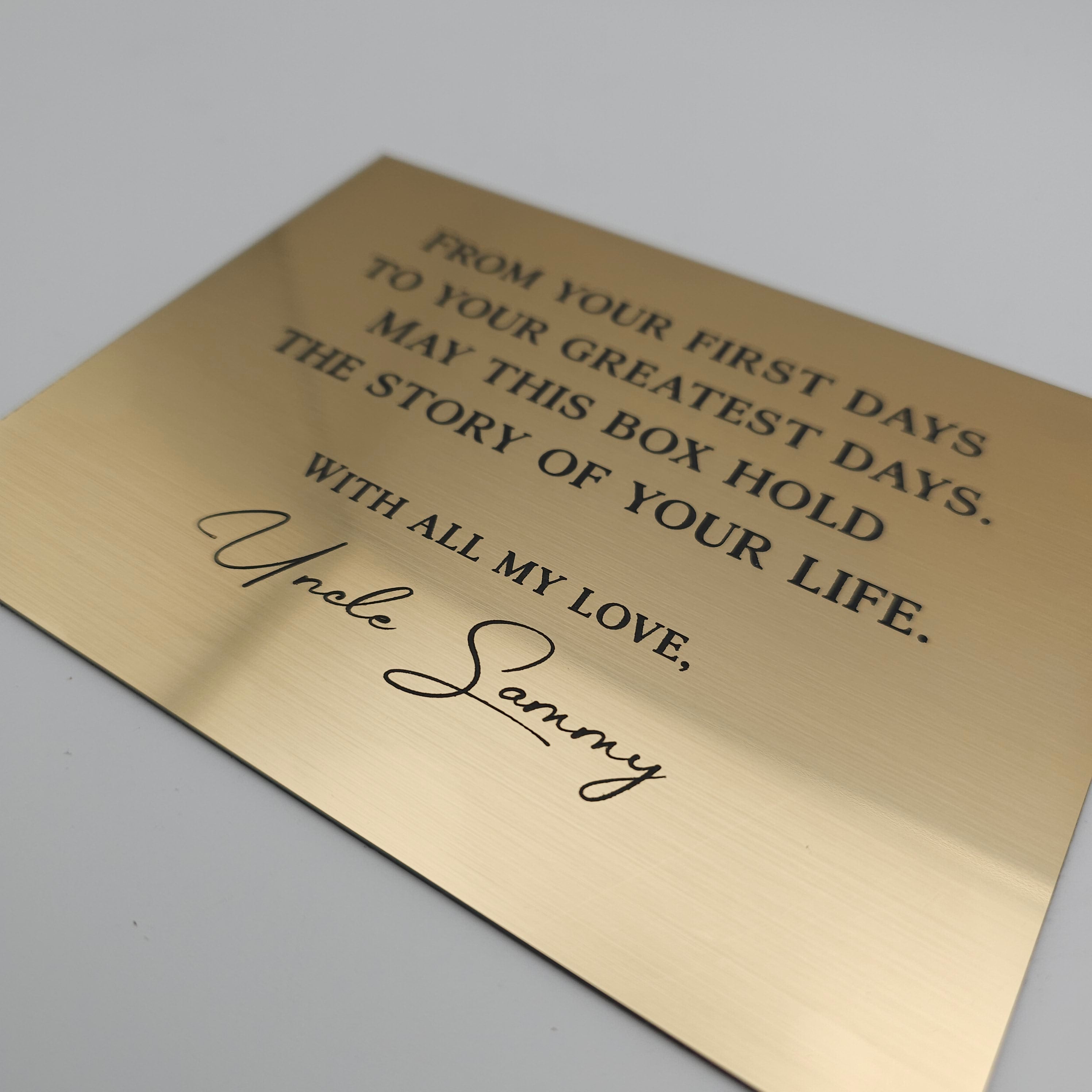 Gold plaque with engraved text on a white background