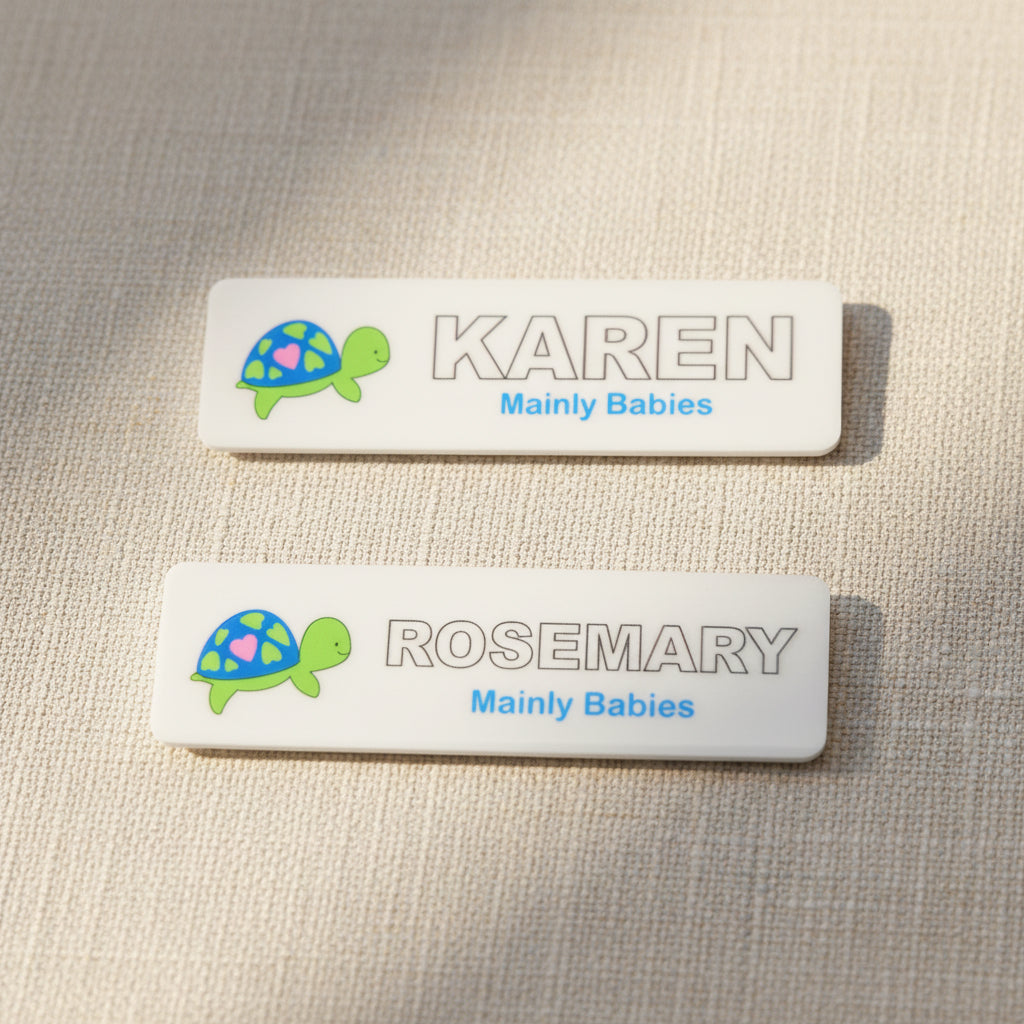 Two name tags with turtle designs on a light gray background