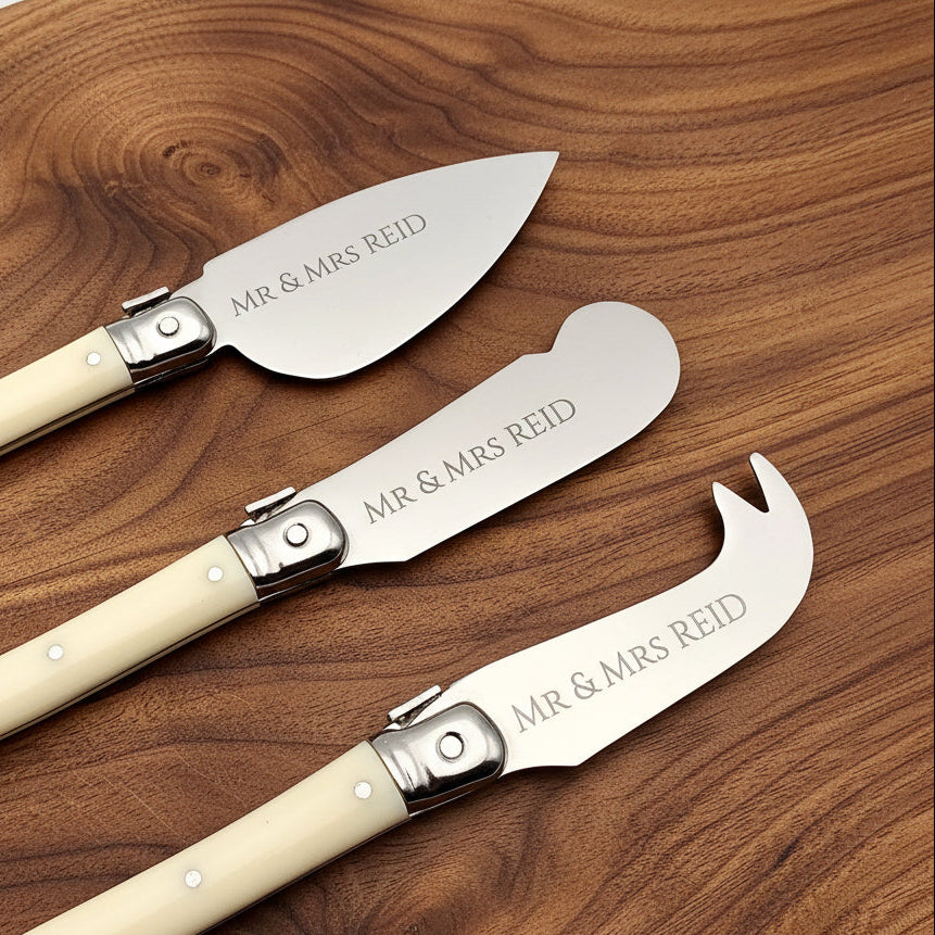 Three pocket knives with 'MR & MRS REID' engraving on a light gray background