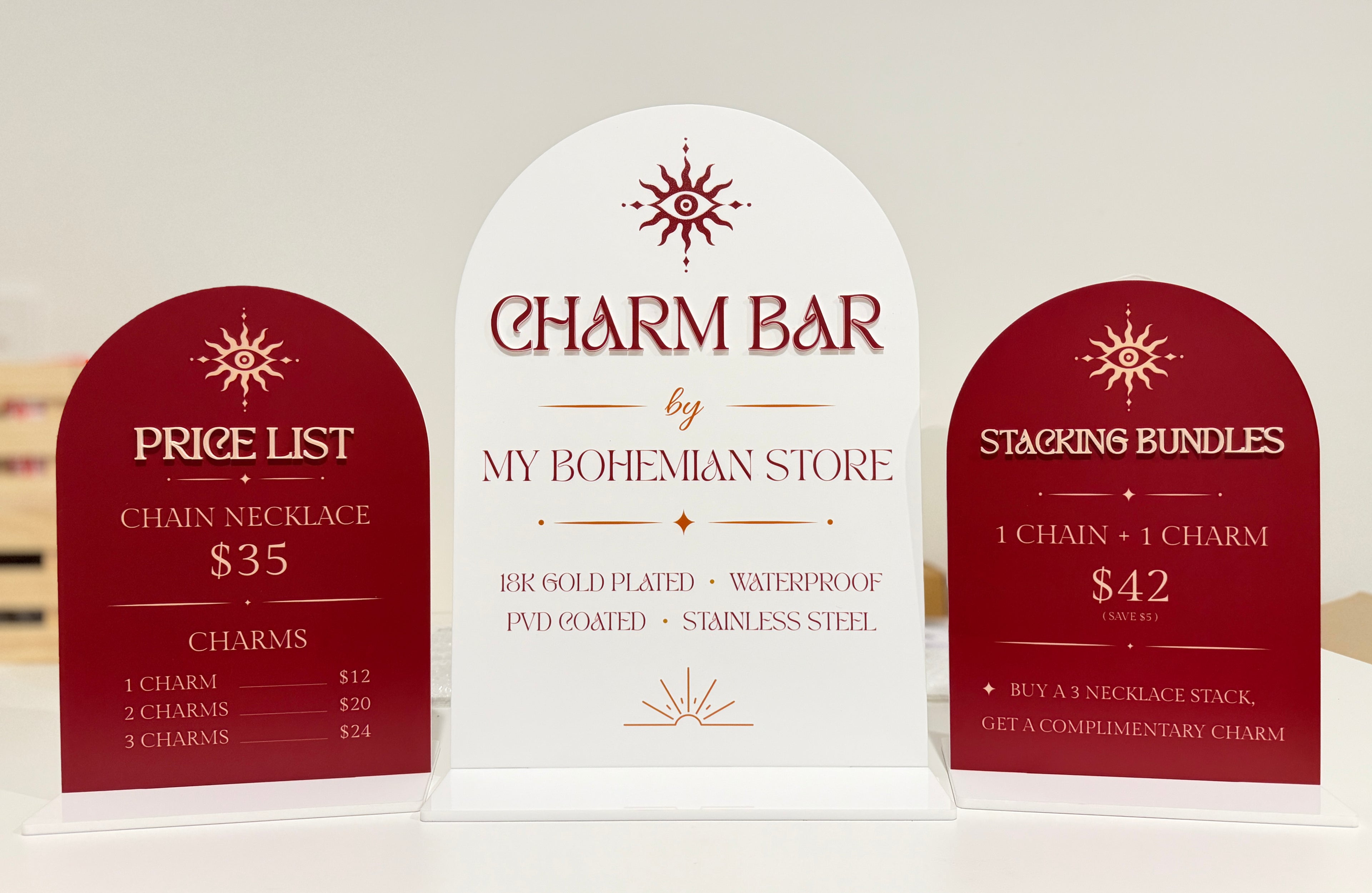 Three signs for a 'Charm Bar' with pricing and product details.