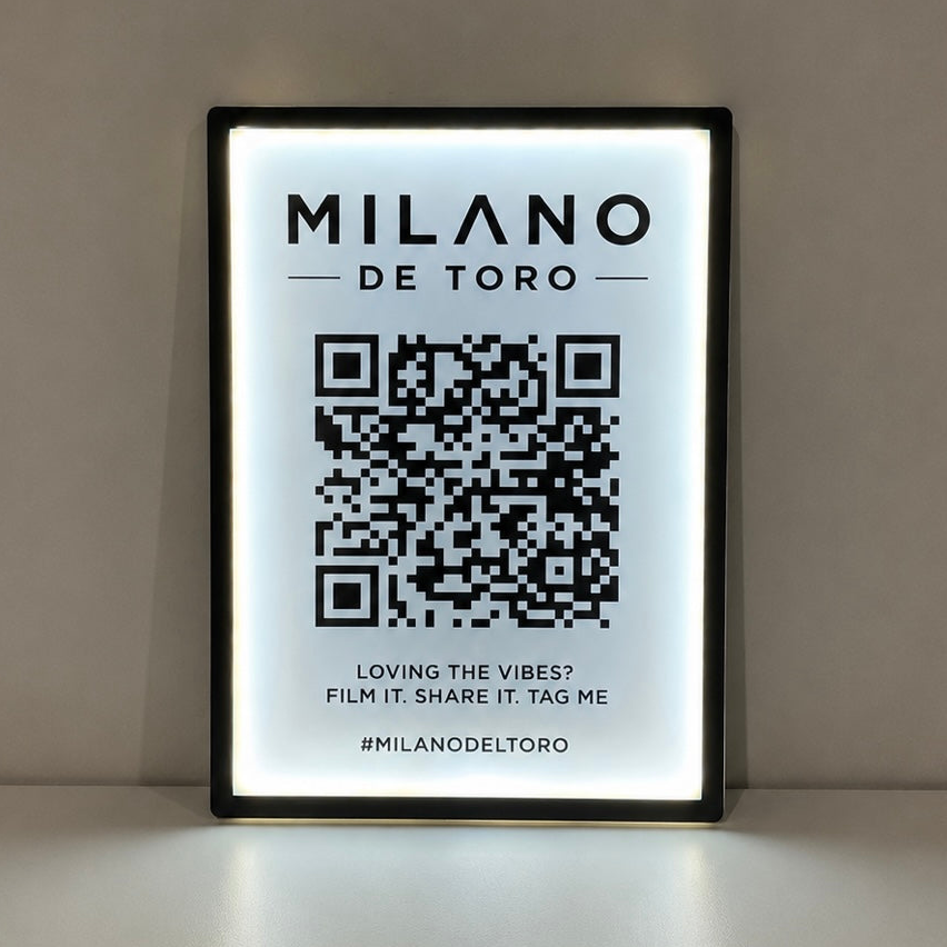 Framed led sign with 'MILANO DE TORO' branding and QR code on a light background