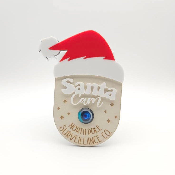 Small device resembling a camera with a Santa hat on a white background