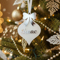 Decorative ornament with 'Isaac' on a green Christmas tree