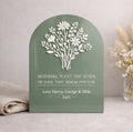 Decorative plaque with floral design and engraved text on a neutral background