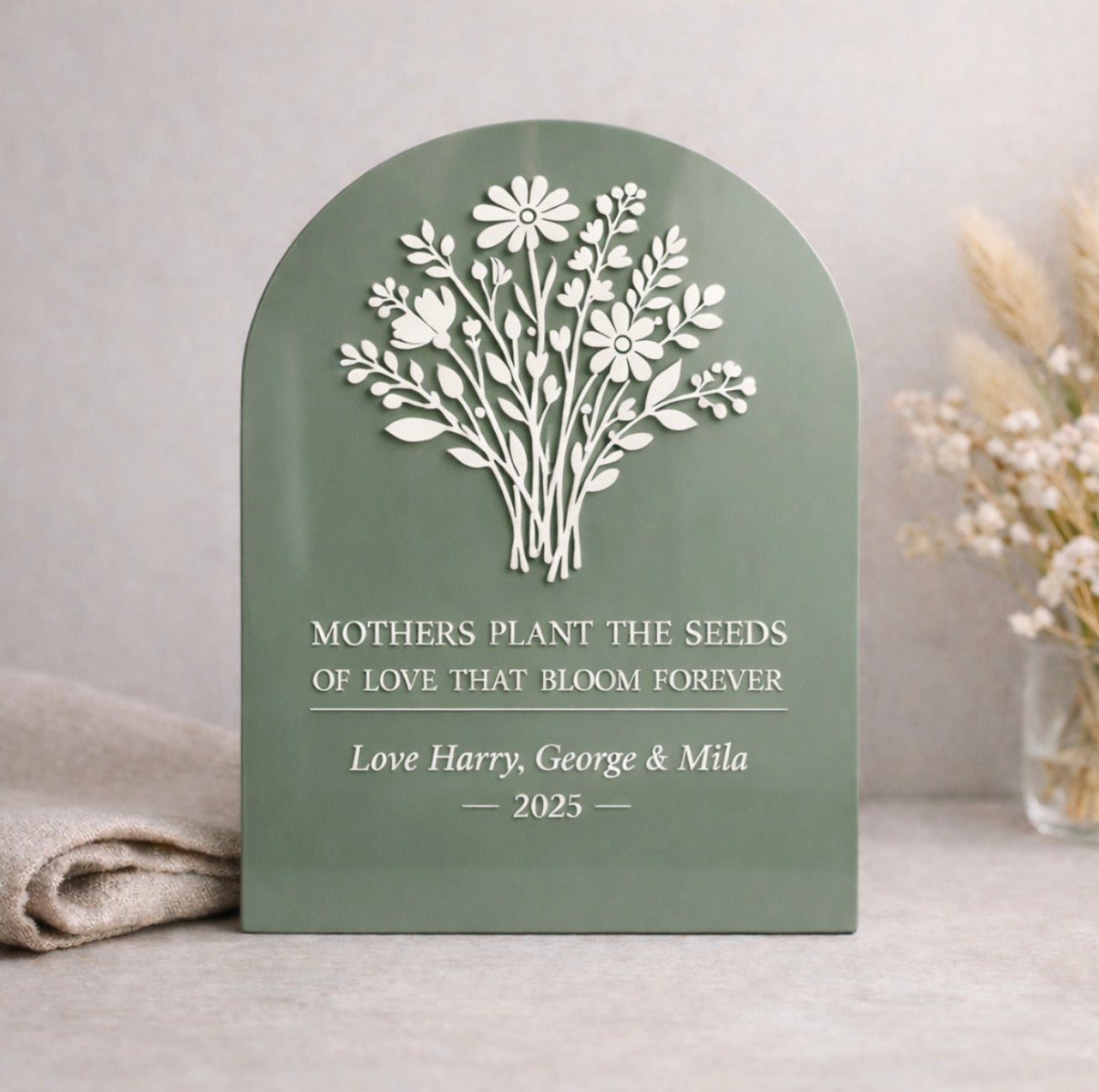 Decorative plaque with floral design and engraved text on a neutral background