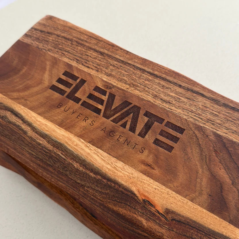 Close-up of real estate business logo engraved on an acacia serving board