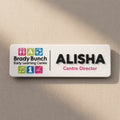 Personalised childcare centre acrylic name badge with Brady Bunch Early Learning Centre logo and Alisha Centre Director text