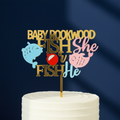 White cake with a gender reveal cake topper on a pink background