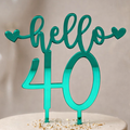 Teal 'hello 40' cake topper on a white cake with a blurred background