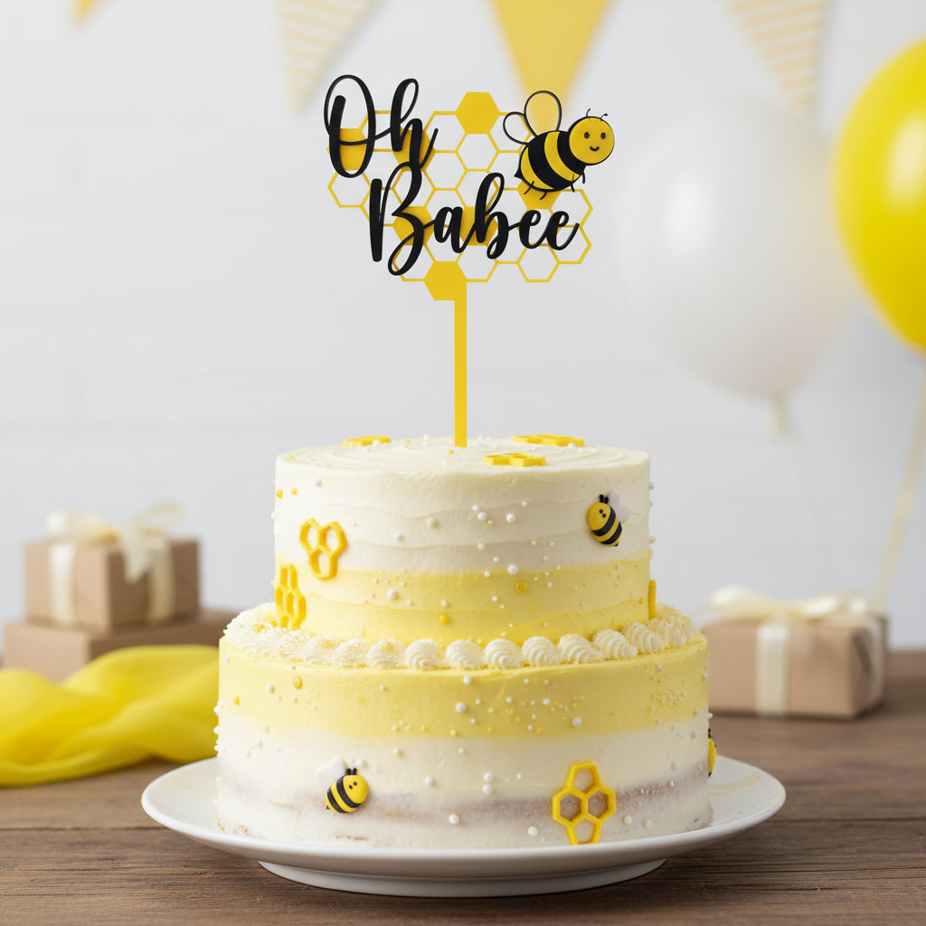 Decorative cake topper with 'Oh Babee' text and a bee design on a white background