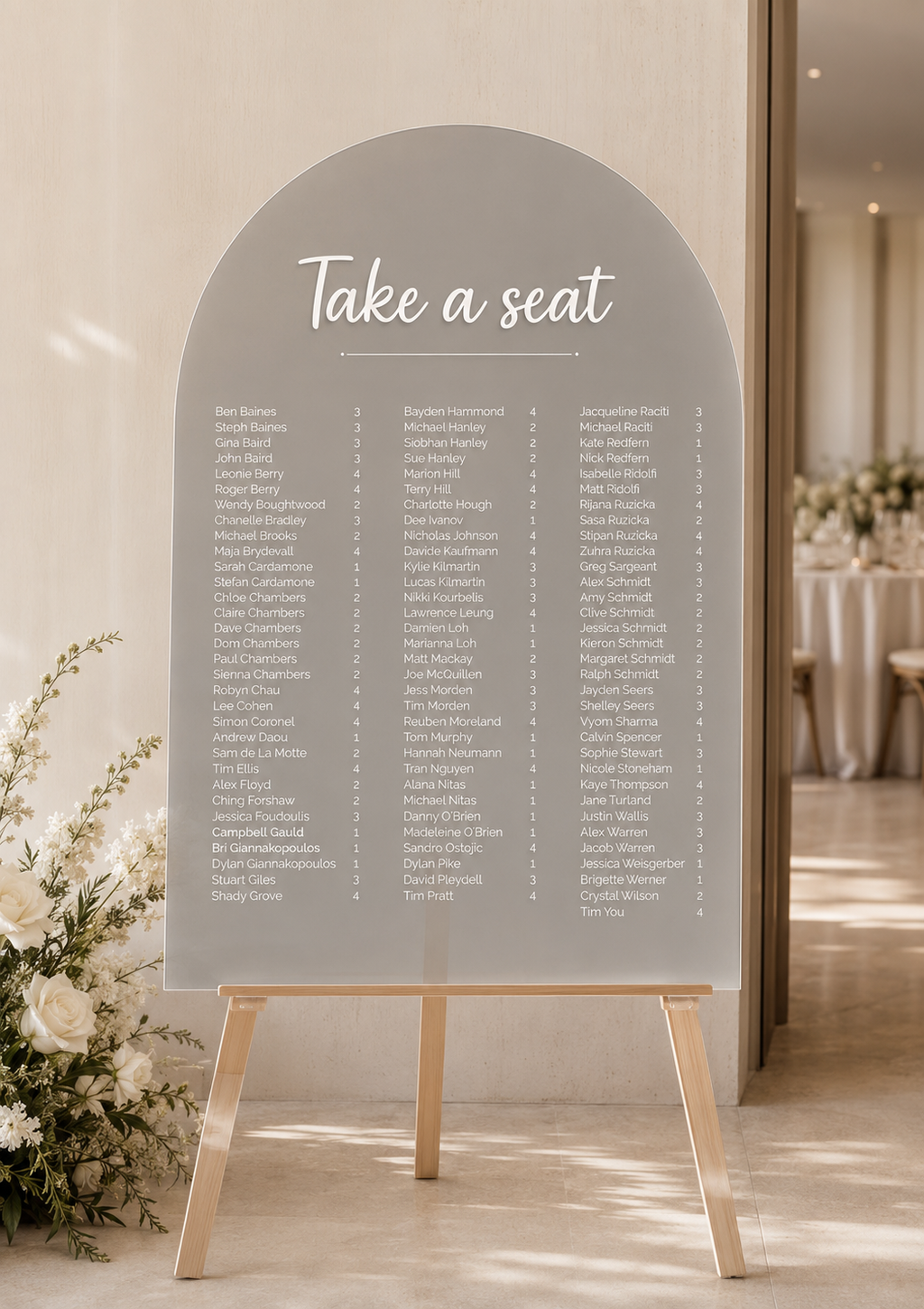 Personalised A1 frosted acrylic arch wedding seating chart with white lettering on an easel