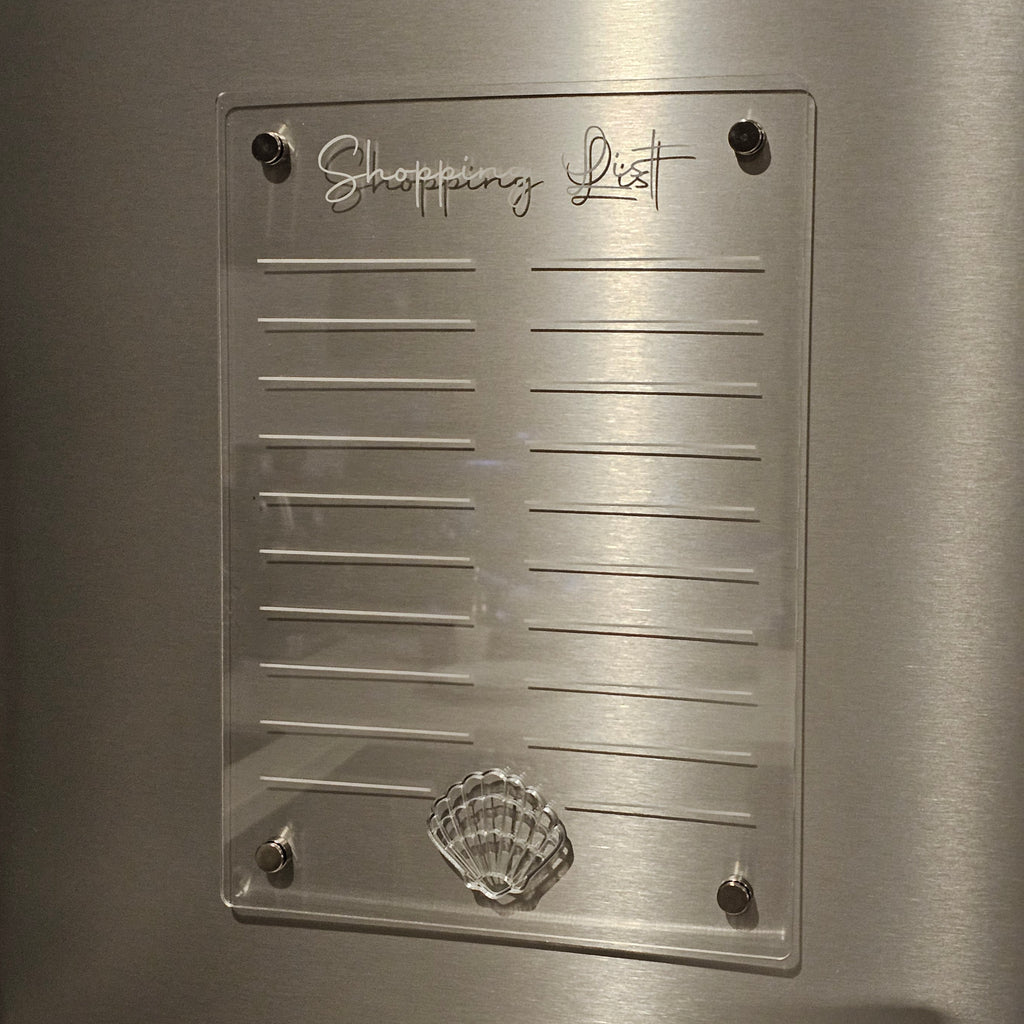 Clear acrylic shopping list with shell design on a metallic surface