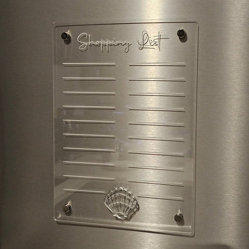 Clear acrylic shopping list with shell design on a metallic surface