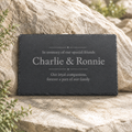 Slate plaque with engraved text on a rock background