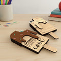 Wooden popsicle-shaped bookmarks with text on a wooden surface.